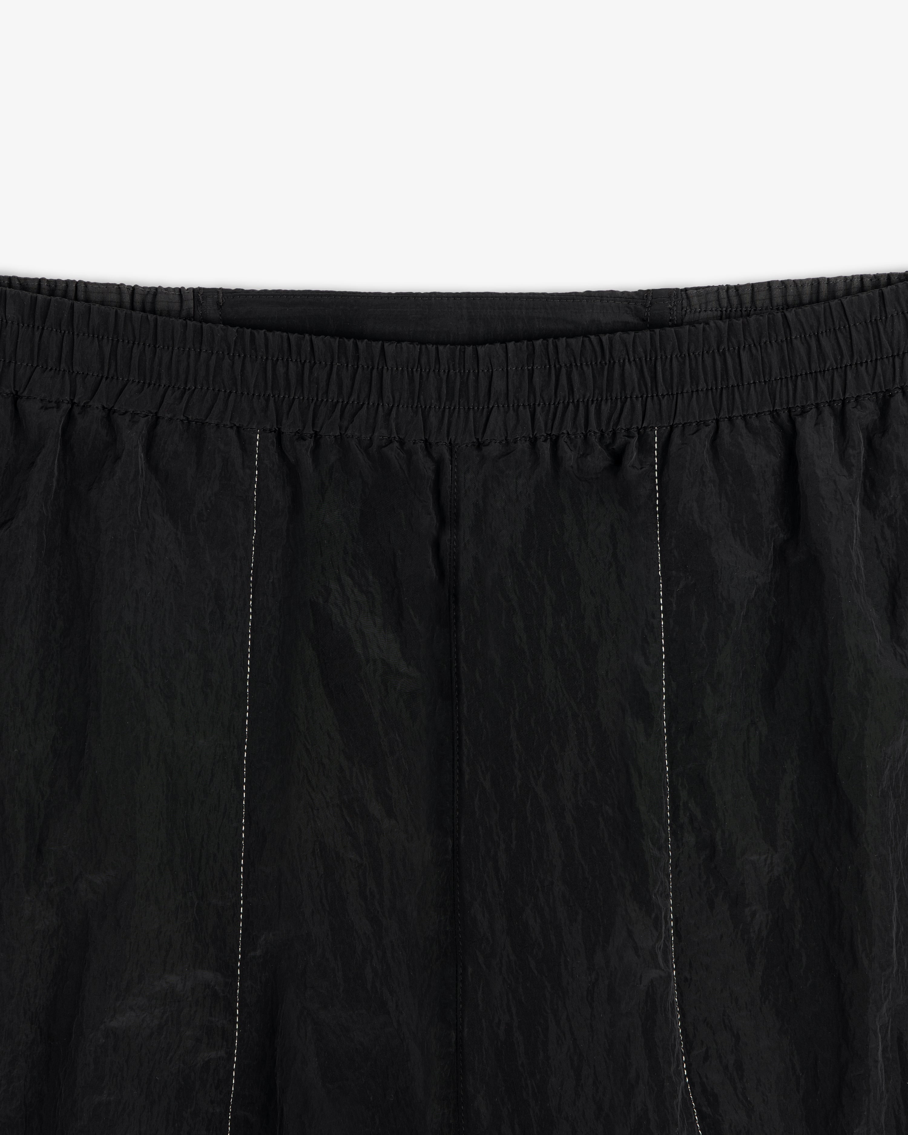 Close-up of ALD / New Balance Lightweight Nylon Warmup Pant with elastic waistband and subtle vertical stitching.
