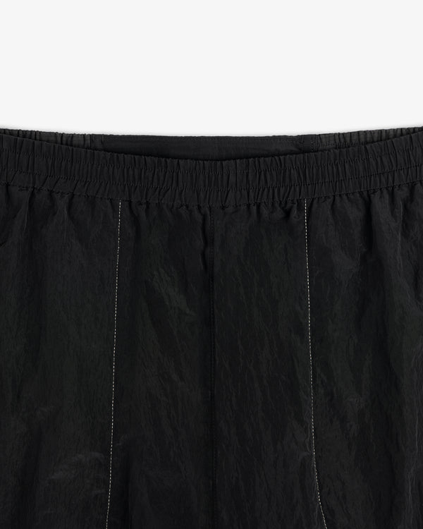 Close-up of ALD / New Balance Lightweight Nylon Warmup Pant with elastic waistband and subtle vertical stitching.