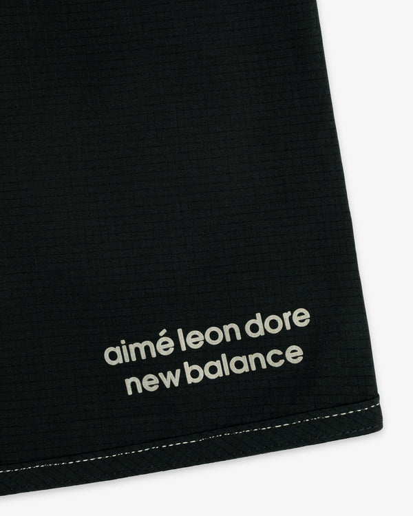Close-up of black ALD / New Balance Performance Lightweight Running Short with white logo near hem and visible stitching.