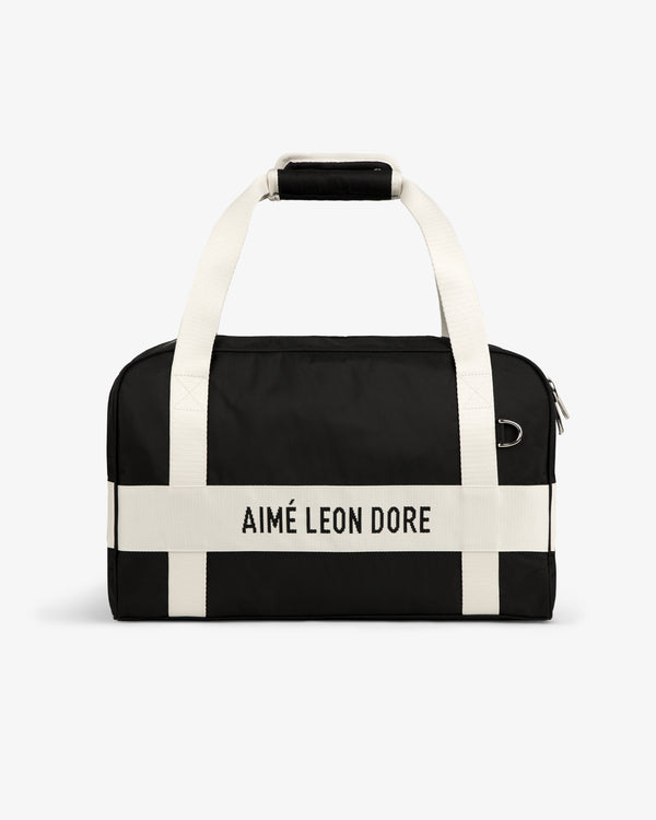 Nylon Duffle Bag with white handles and AIMÉ LEON DORE white strap, shown against a white background.