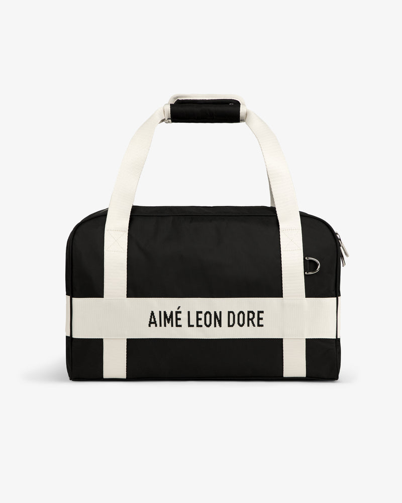 Nylon Duffle Bag with white handles and AIMÉ LEON DORE white strap, shown against a white background.