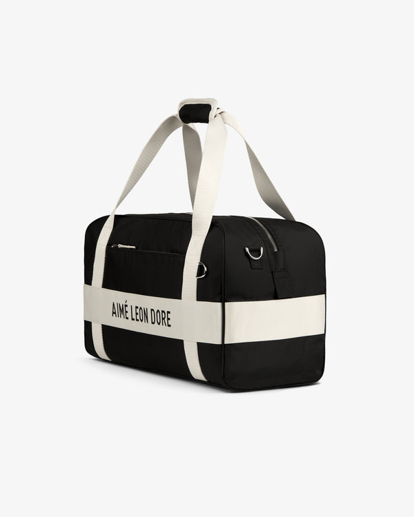 Black Nylon Duffle Bag by Aimé Leon Dore with white straps and logo, displayed on a white background.