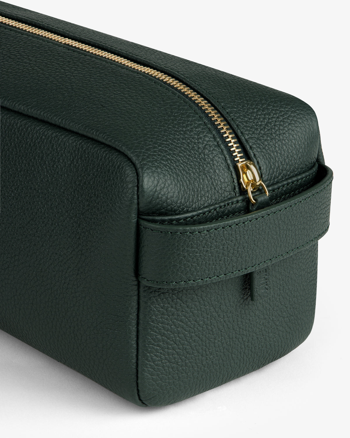 A close-up of the Leather Traveler Kit—a dark green leather bag with a gold zipper and side handle.