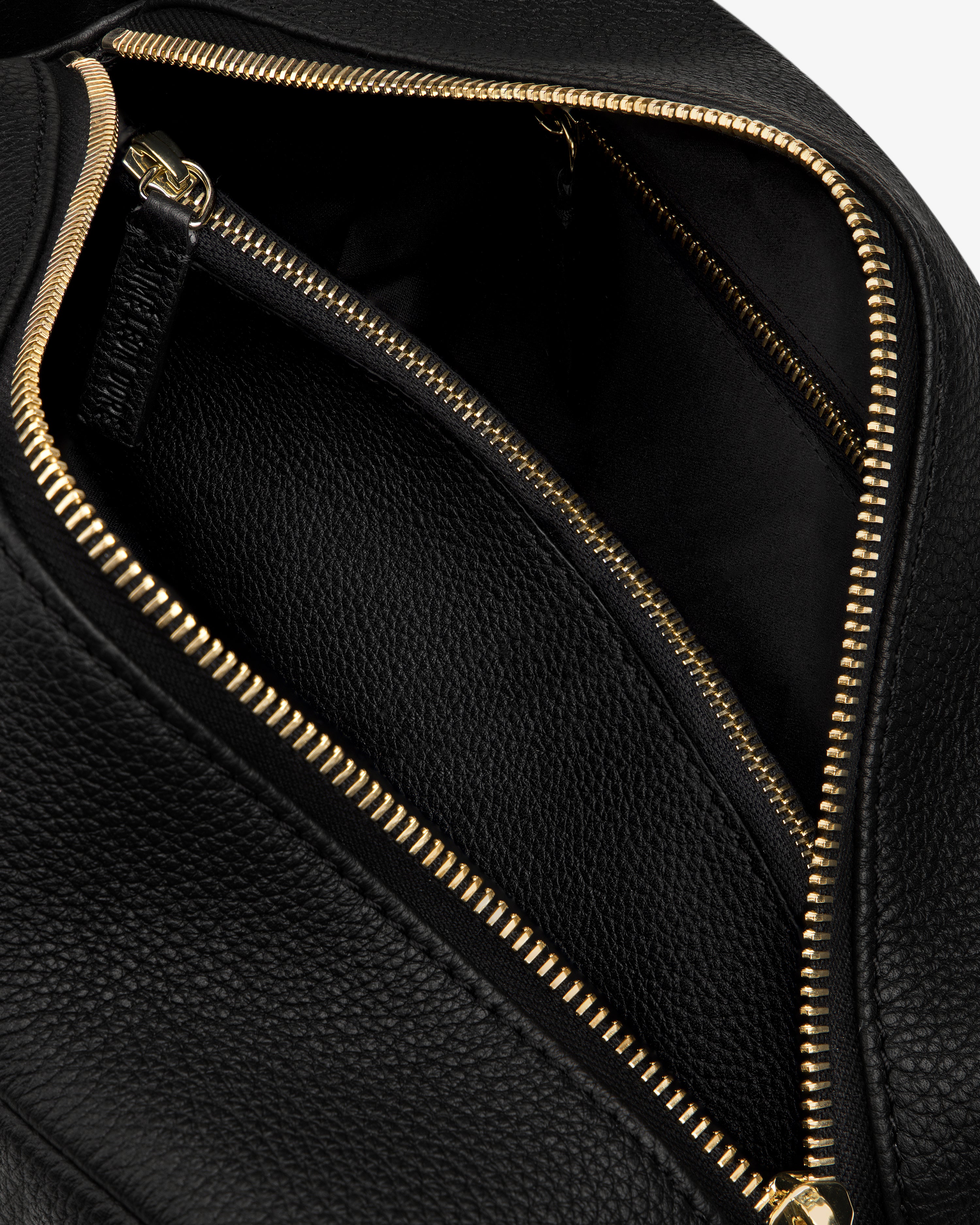 Close-up of the Leather Traveler Kit, open to reveal a spacious interior and an inner zippered pocket.