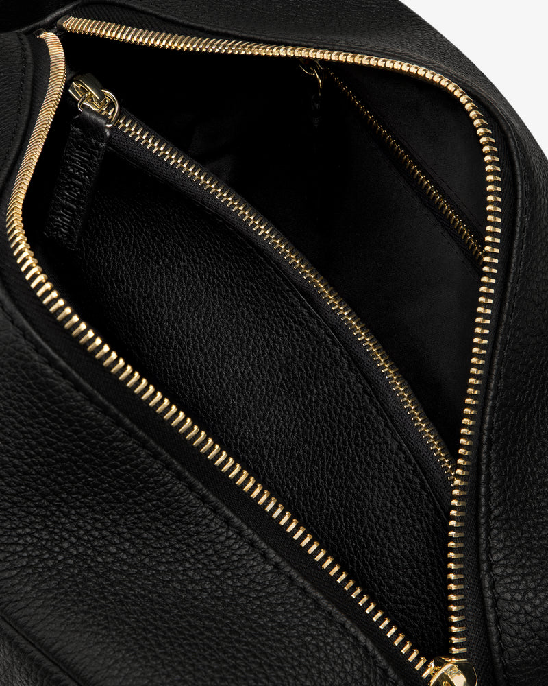 Close-up of the Leather Traveler Kit, open to reveal a spacious interior and an inner zippered pocket.