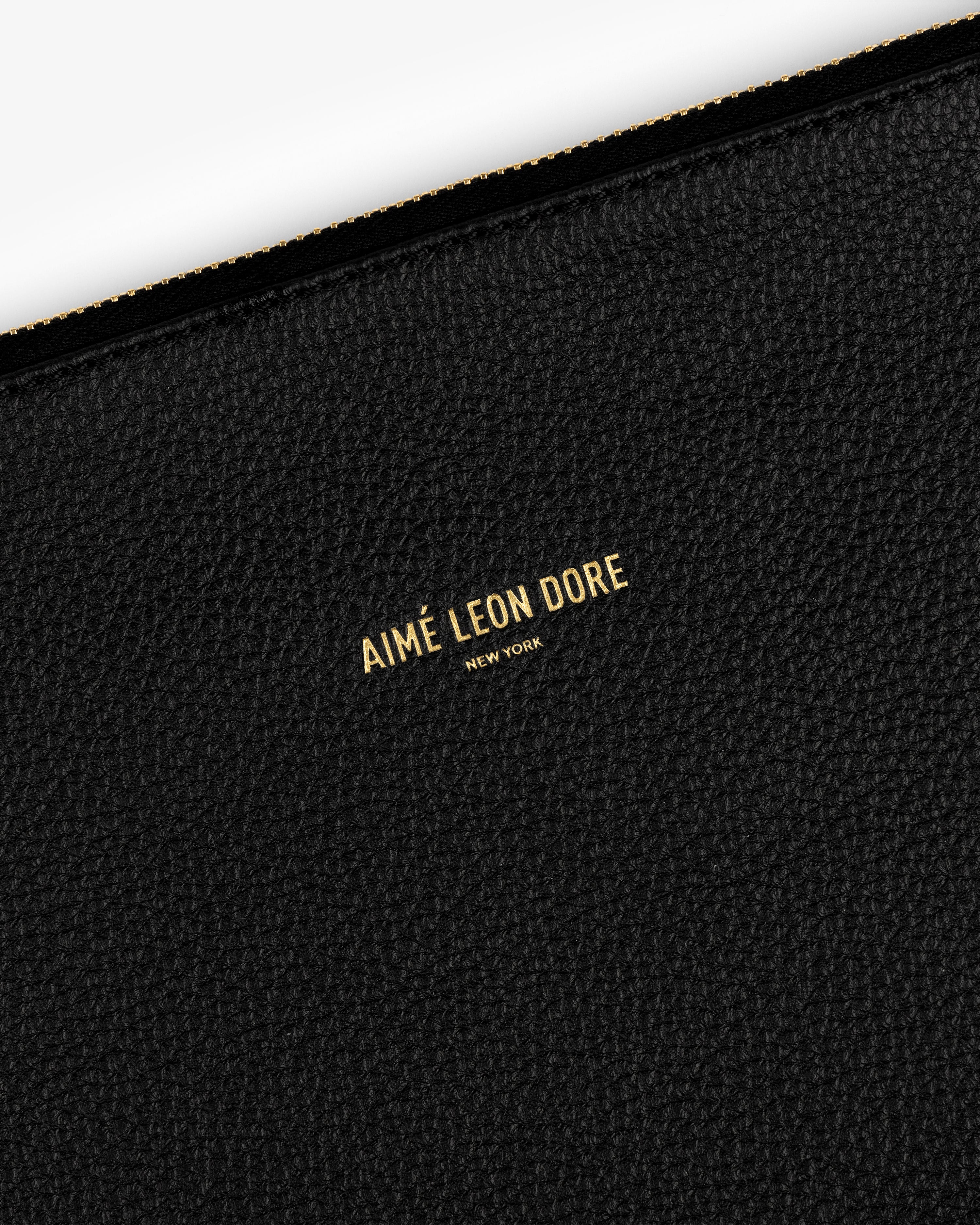 Black textured Small Leather Pouch with AIMÉ LEON DORE NEW YORK printed in gold at the center.