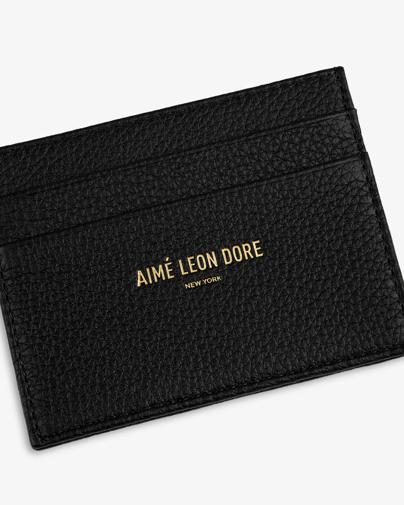 Black textured Leather Card Holder with AIMÉ LEON DORE NEW YORK embossed in gold on the front.