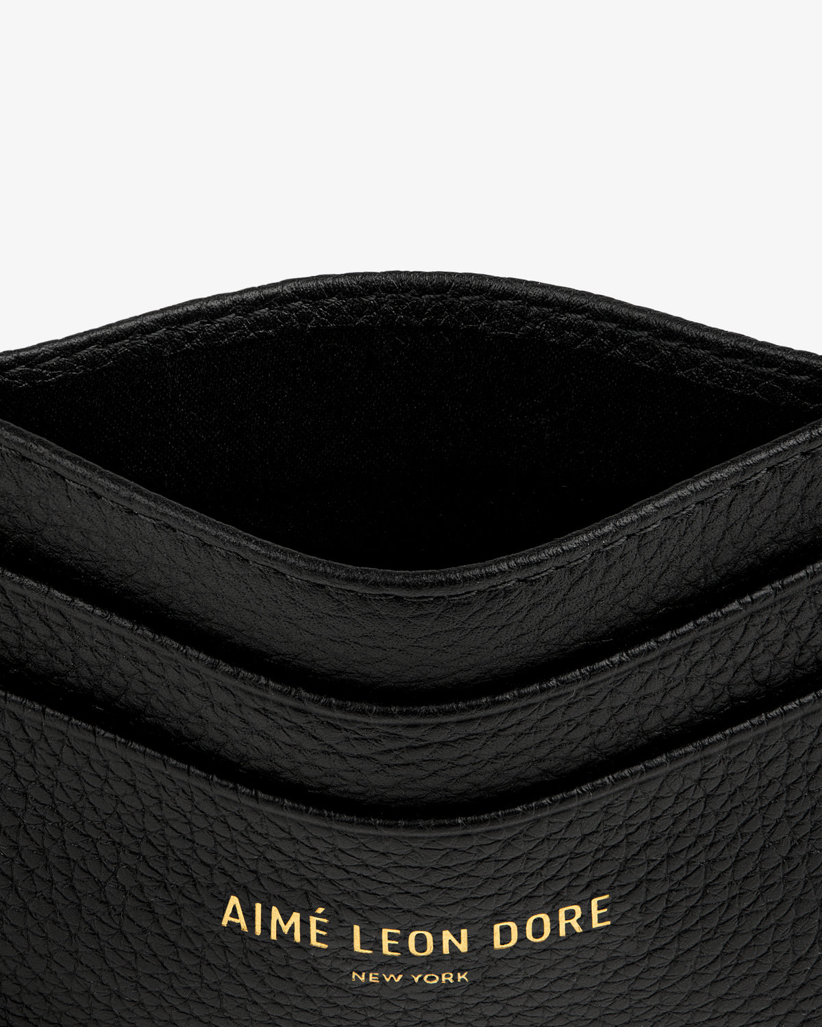 Leather Card Holder in black with gold AIMÉ LEON DORE NEW YORK text embossed on the front.