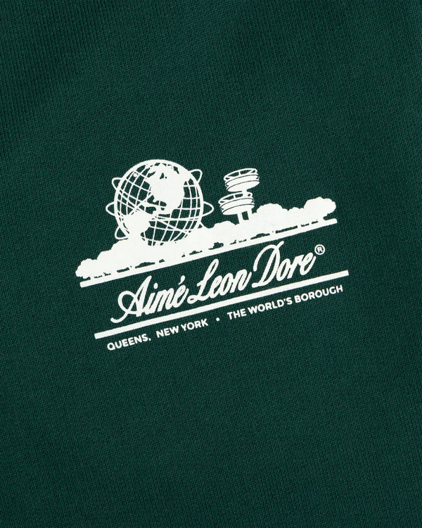 White Aimé Leon Dore Unisphere logo with globe, UFO, and text on dark green Unisphere Sweatpants.