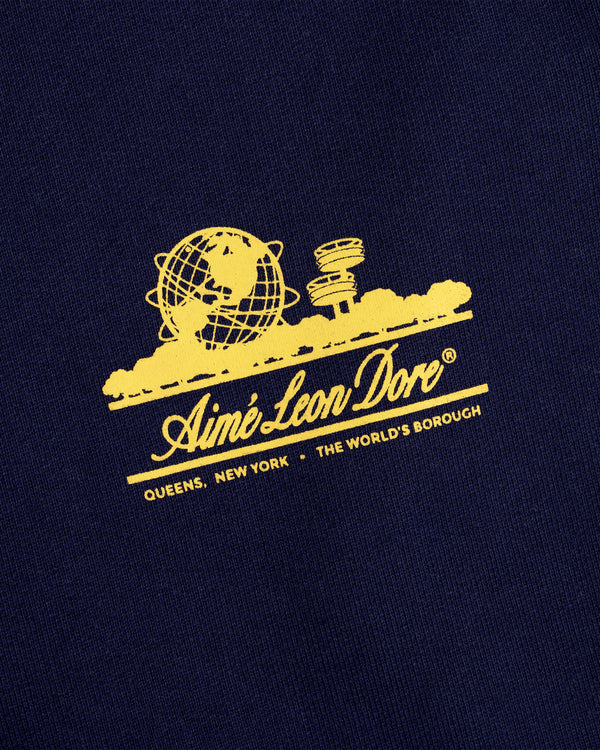 Yellow Aimé Leon Dore globe and text on navy blue Unisphere Sweatpants, referencing Queens, New York.