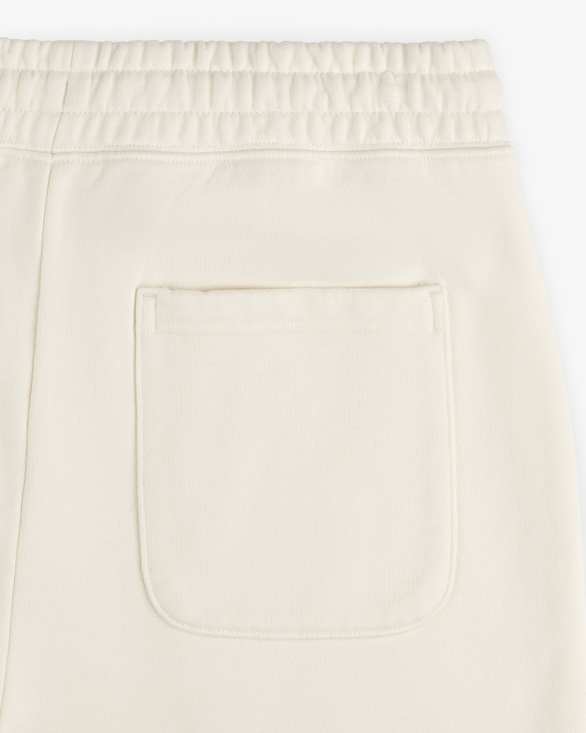 Close-up of Unisphere Sweatpants in cream with an elastic waistband and a single square back pocket.