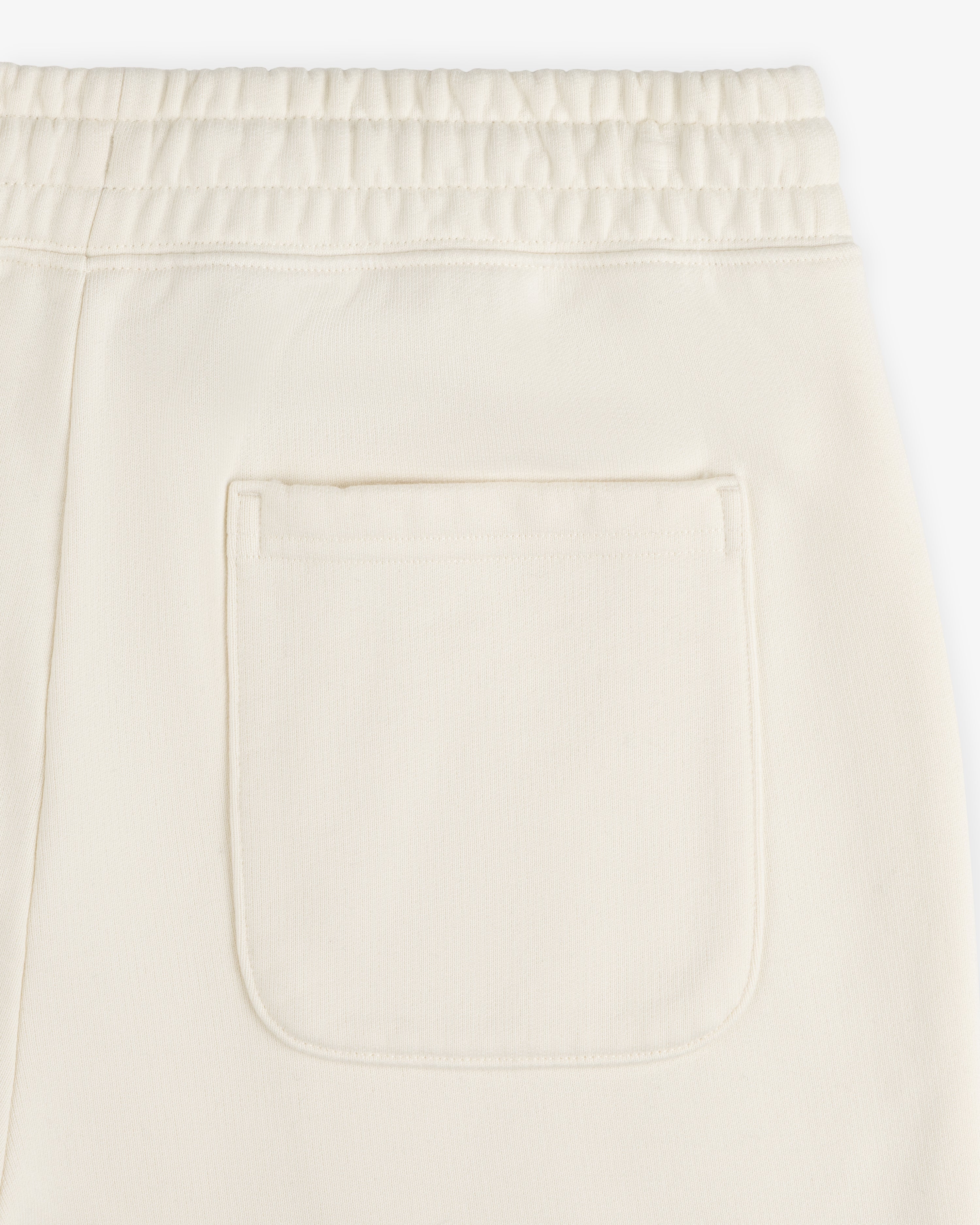 Close-up of Unisphere Sweatpants in cream with an elastic waistband and a single square back pocket.