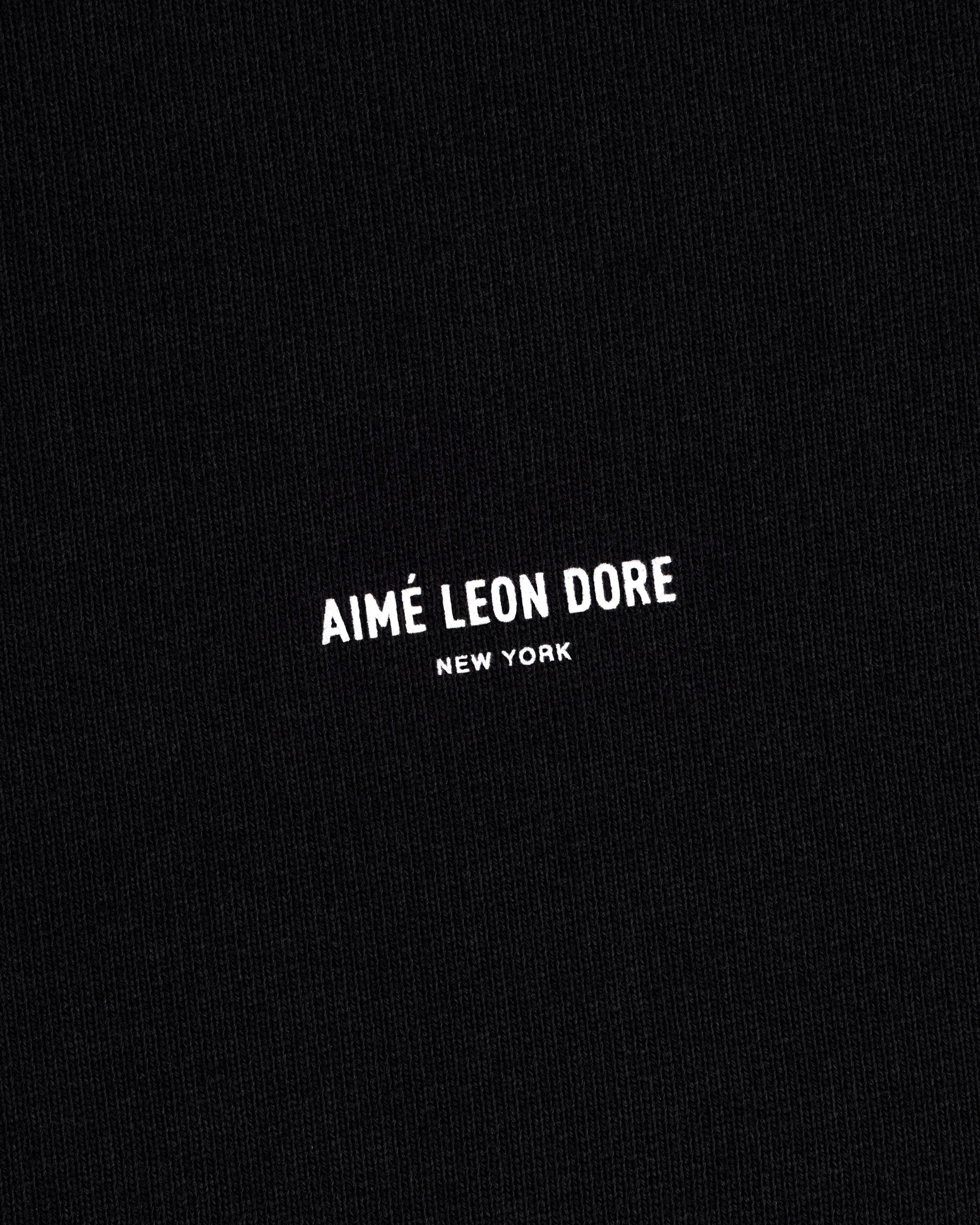 Black Micro Logo Crewneck Sweatshirt with small white "AIMÉ LEON DORE NEW YORK" text centered on fabric.
