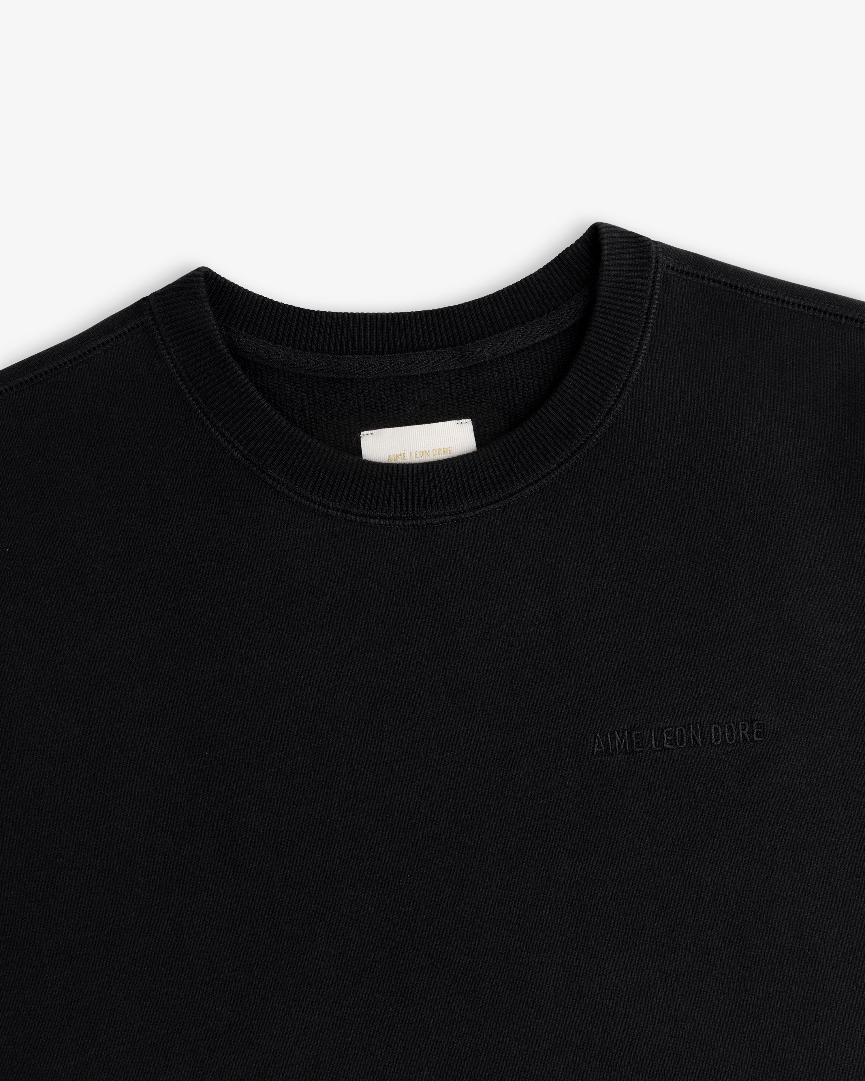 Tonal Logo Crewneck Sweatshirt in black with subtle embroidered logo and white collar label.