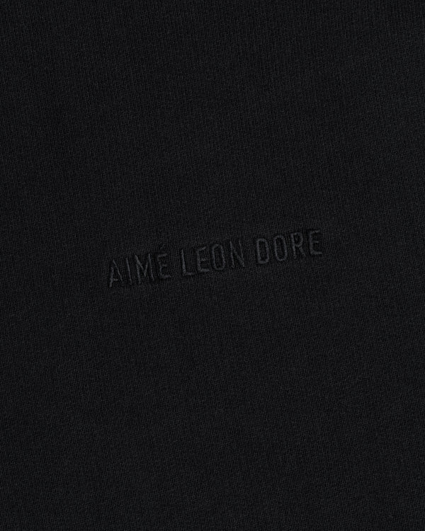 Close-up of black Tonal Logo Crewneck Sweatshirt with "AIME LEON DORE" embroidered in matching black thread.