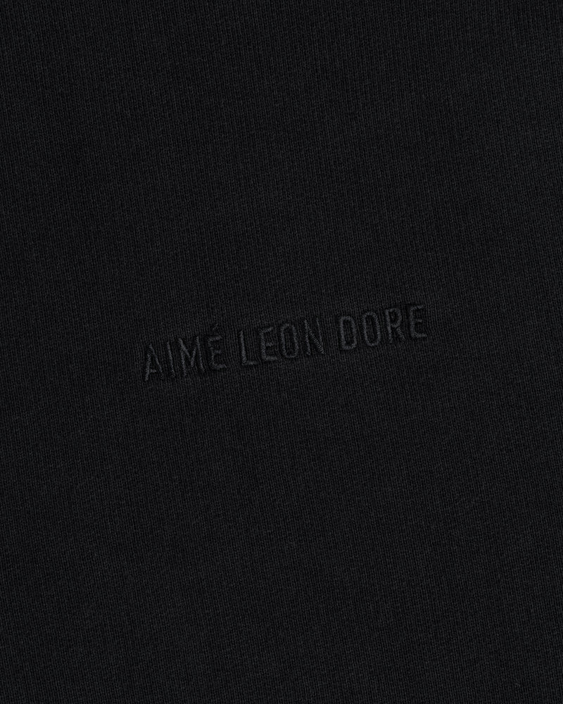 Close-up of black Tonal Logo Crewneck Sweatshirt with "AIME LEON DORE" embroidered in matching black thread.