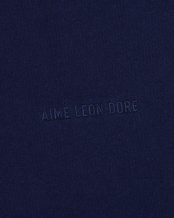 Close-up of navy blue Tonal Logo Crewneck Sweatshirt with AIMÉ LEON DORE subtly embossed in the center.