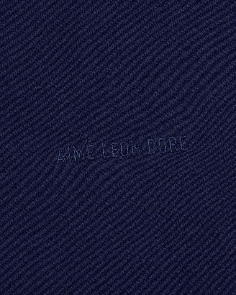 Close-up of navy blue Tonal Logo Crewneck Sweatshirt with AIMÉ LEON DORE subtly embossed in the center.