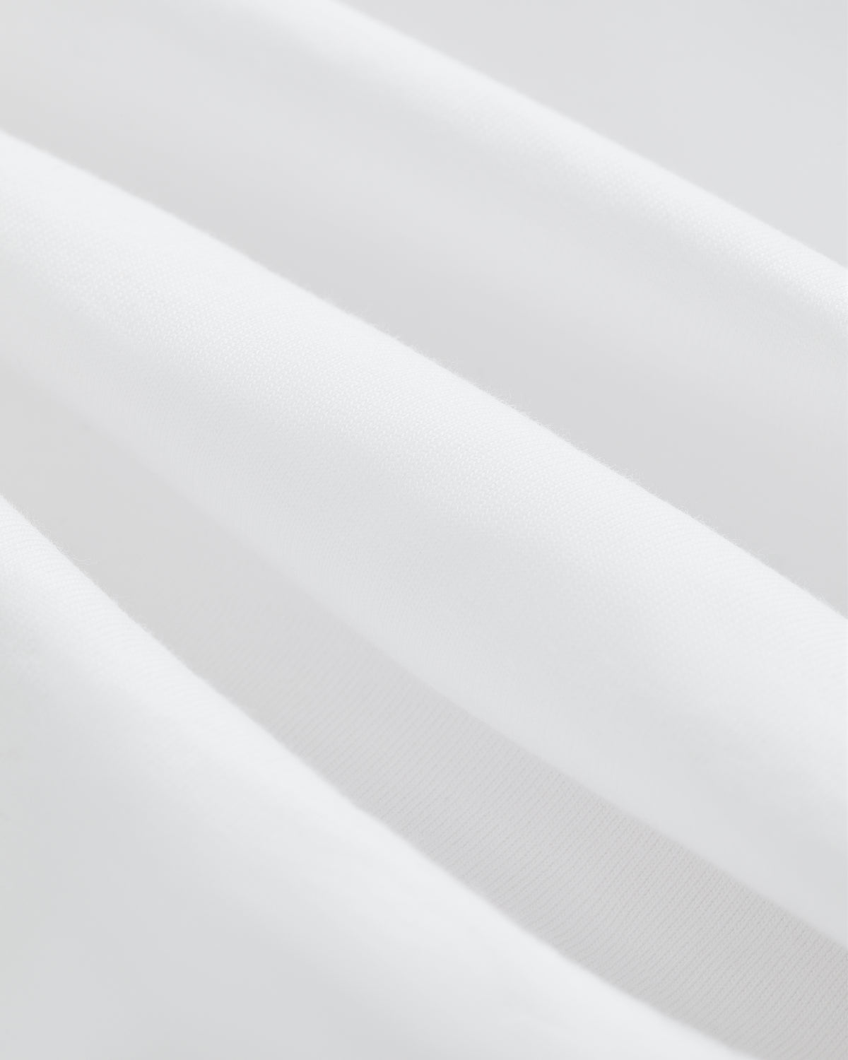 Close-up of soft, white T-Shirt 3-Pack fabric with gentle folds for a smooth, clean texture.