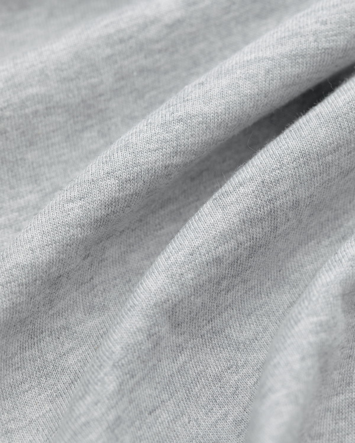 Close-up of light gray fabric from Multi-Color T-Shirt 3-Pack, with soft folds and a smooth, slightly textured surface.