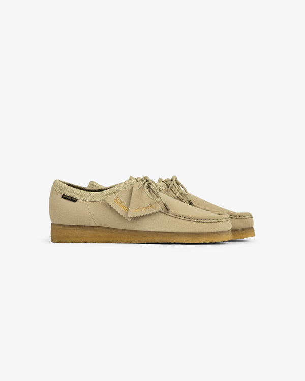 ALD / Clarks Suede Wallabee in beige with crepe soles, visible stitching, and side tags on a white background.