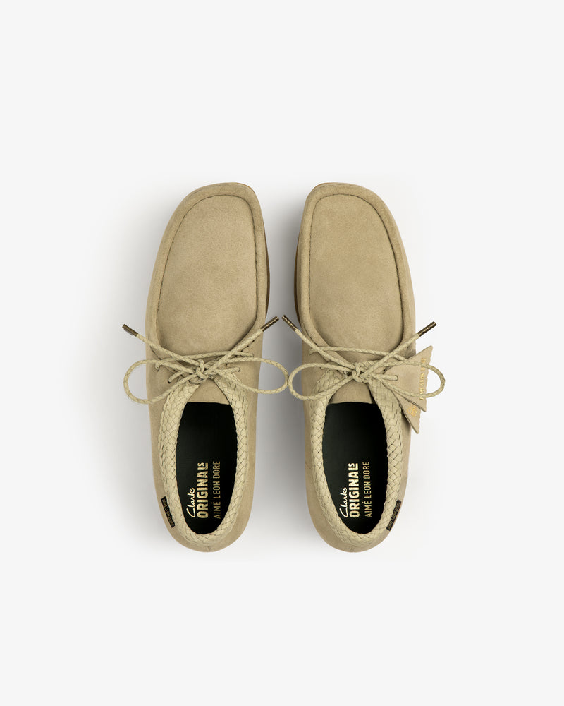 ALD / Clarks Suede Wallabee in tan, seen from above with lace-up detail, visible insoles, and square toe on white.