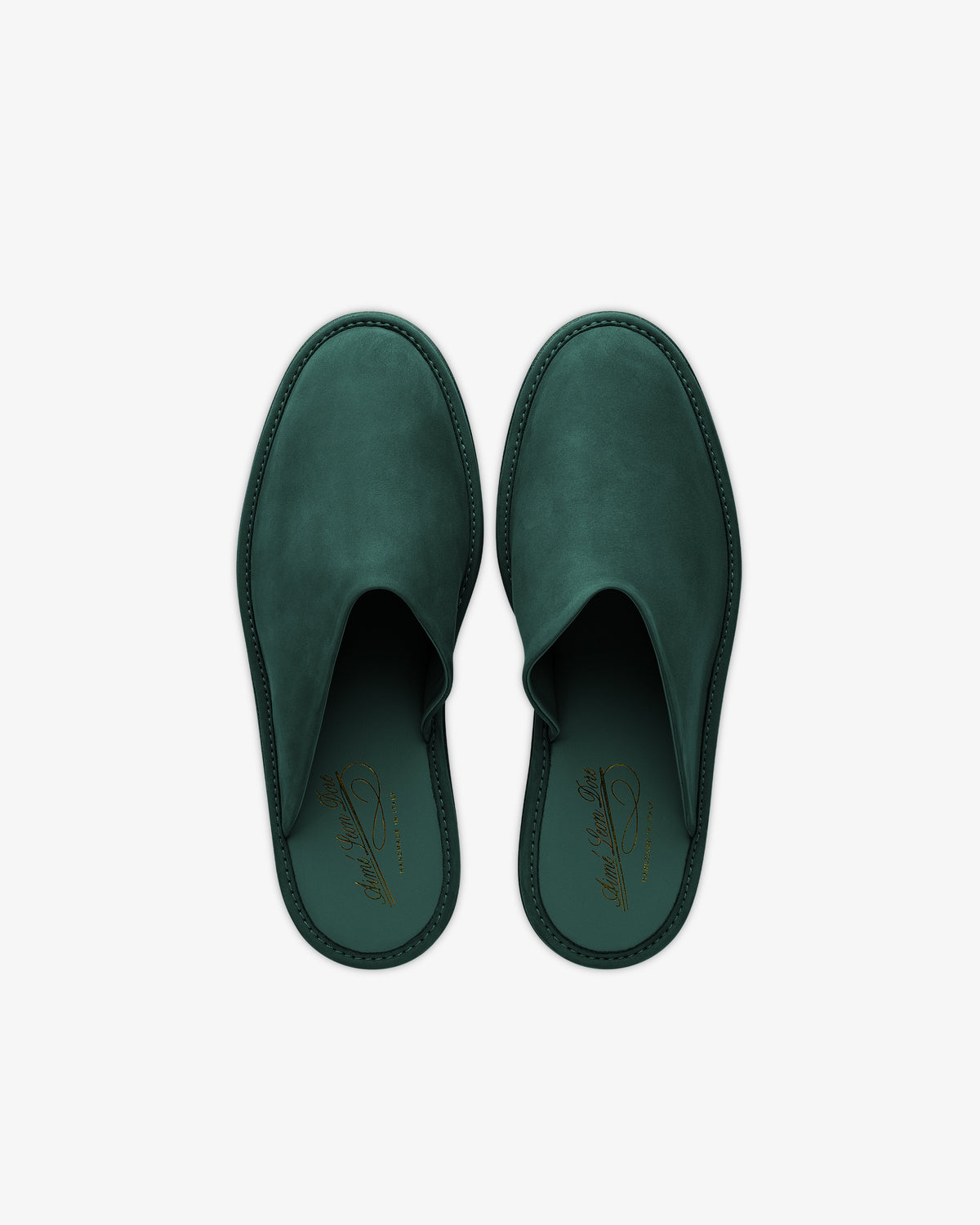 A pair of green Nubuck Travel Slippers with closed toes and a gold insole logo, shown from above on a white background.