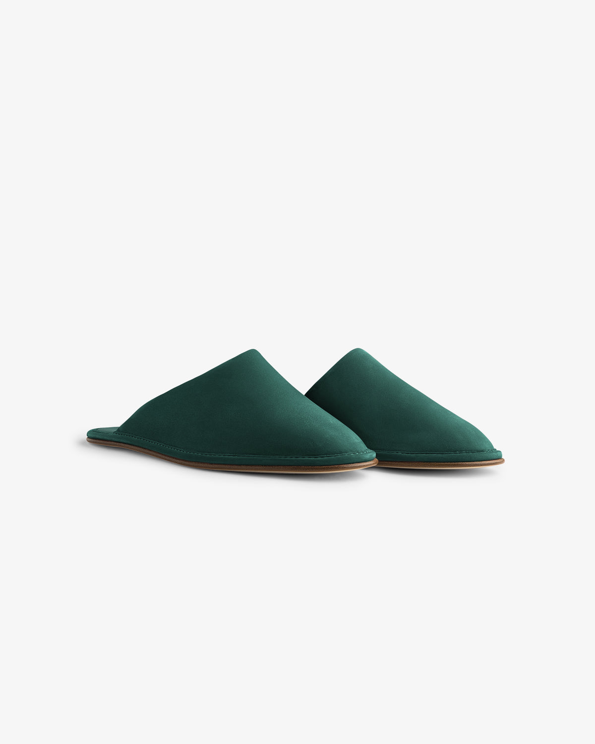 The Nubuck Travel Slipper is a pair of dark green slip-on slippers with flat brown soles on a white background.