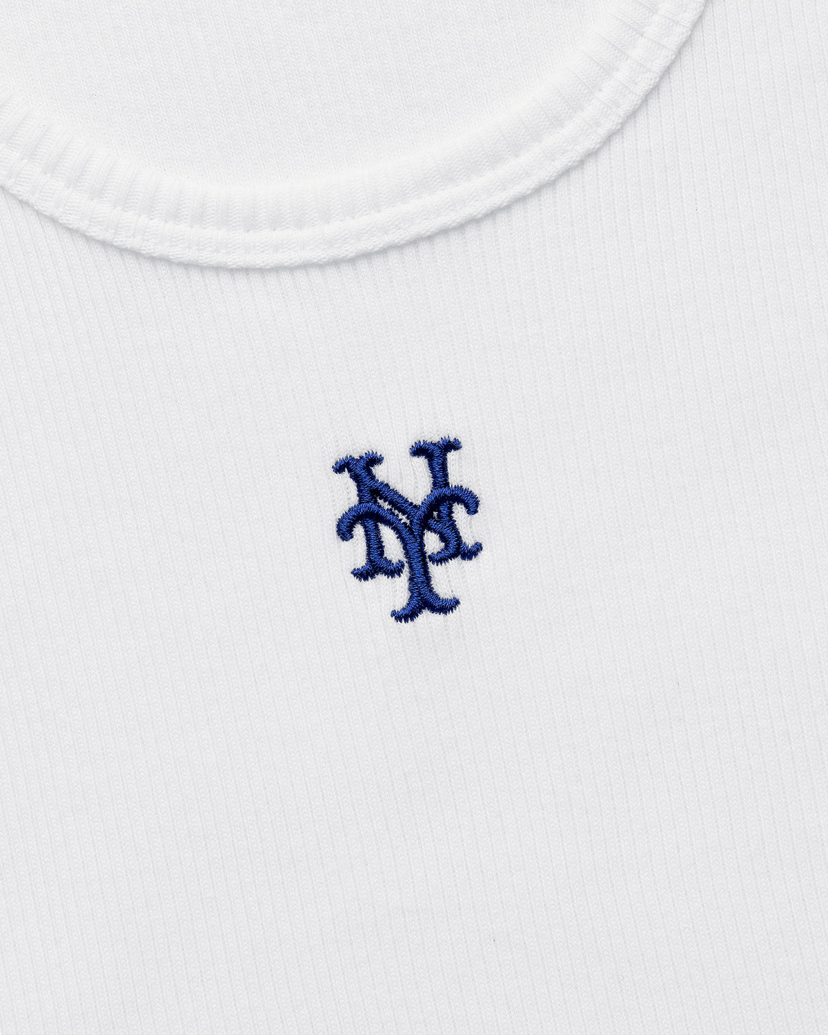 Close-up of the Mets Tank Top, a white ribbed shirt featuring a blue New York Mets logo embroidered on the chest.