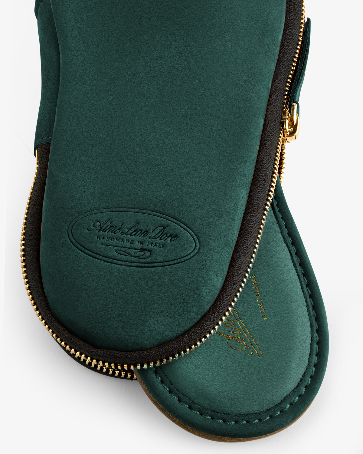 Dark green Nubuck Travel Slipper in zippered pouch, both with gold accents and matching green leather details.