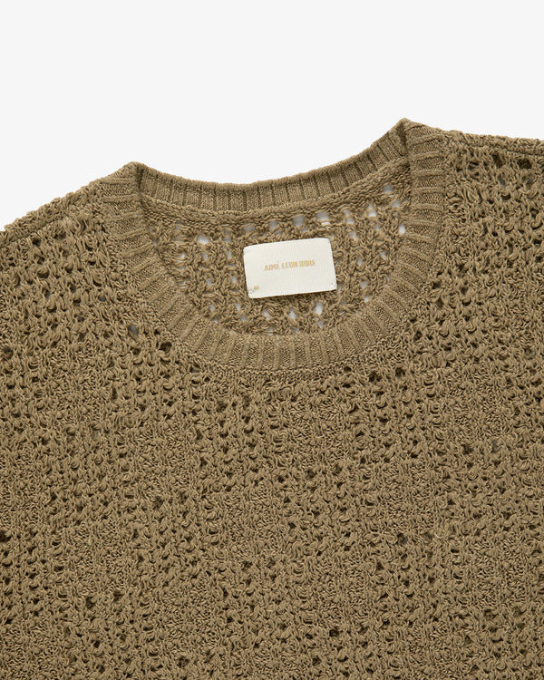 Close-up of the Checkered Crewneck Sweater featuring a brown crochet knit and white label on the neckline.