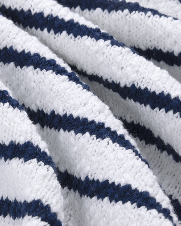 Close-up of the Nautical Rollneck Sweater’s white knit with dark blue stripes and textured, wavy folds.