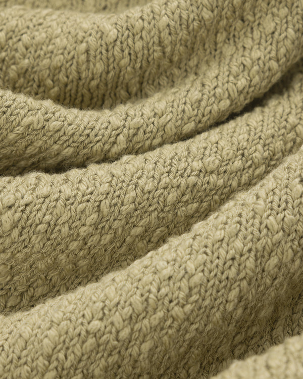 Close-up of the Nautical Rollneck Sweater in olive green, showing its textured knit and soft, visible stitches.