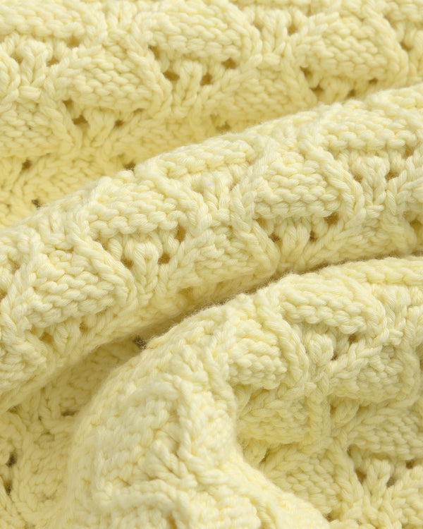 Close-up of a soft, yellow Eyelet Knit Crewneck Sweater with a textured, patterned design.