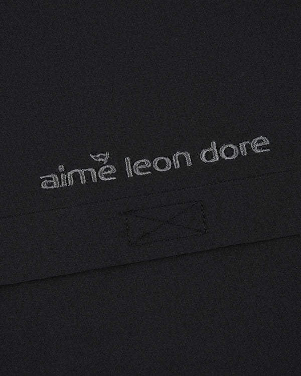 Close-up of black ALD Golf Cordura Tips Jacket with aimé leon dore embroidered in light gray thread.