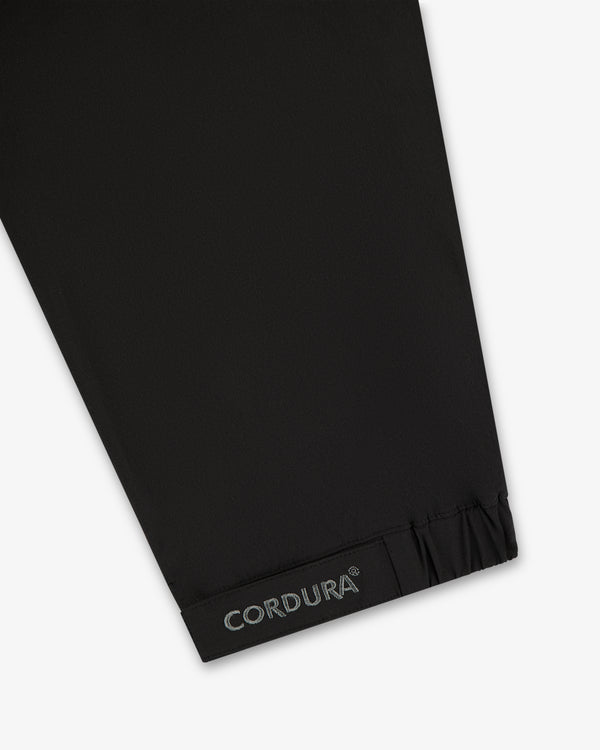Black CORDURA fabric near gathered hem, from the ALD Golf Cordura Tips Jacket—likely part of sleeve or pant leg.