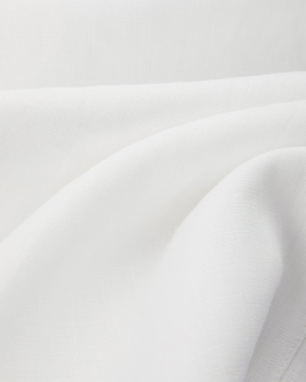 Close-up of smooth, white Linen Leisure Pant fabric with gentle folds and subtle woven texture.