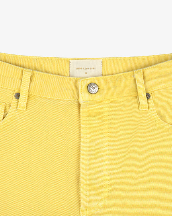 Close-up of Garment Dyed Relaxed Fit Denim waist with metal button, belt loops, and inner brand label.