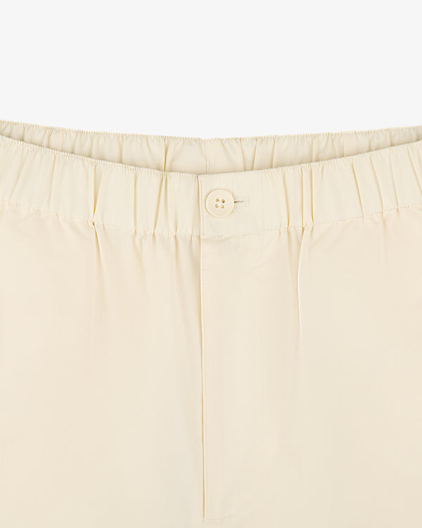 Close-up of Cotton Casual Pant in cream with elastic waistband and a single front button.