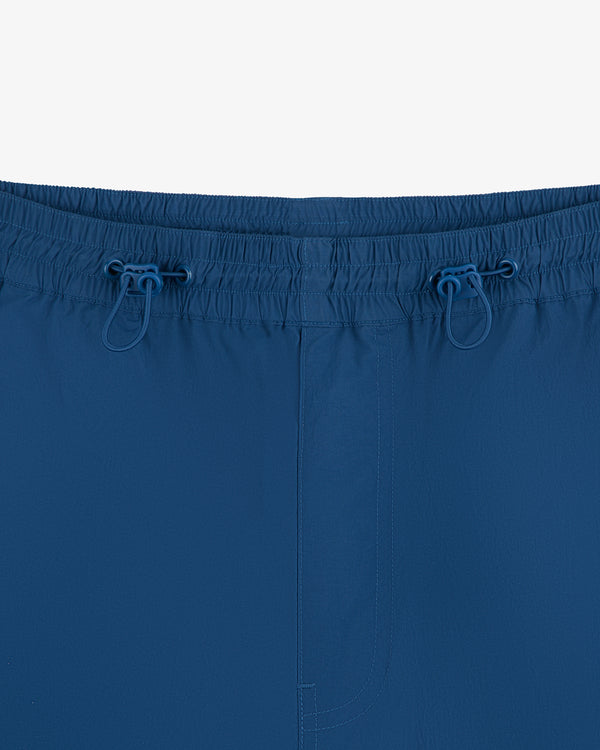 Close-up of Windbreaker Pant featuring an elastic waistband and two blue drawstrings, shown on a white background.