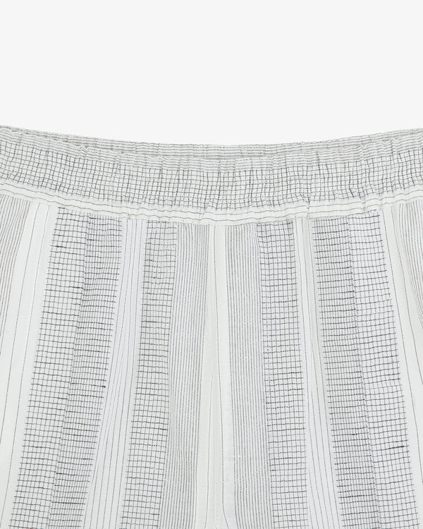 Close-up of Fil Coupé Leisure Pant with a white elastic waistband and thin black vertical, checkered stripes.