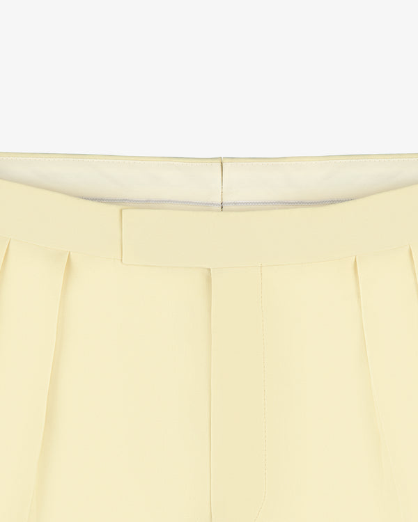 Close-up of Gabardine Suit Trouser in cream with pleats and a concealed waistband, shown on a white background.