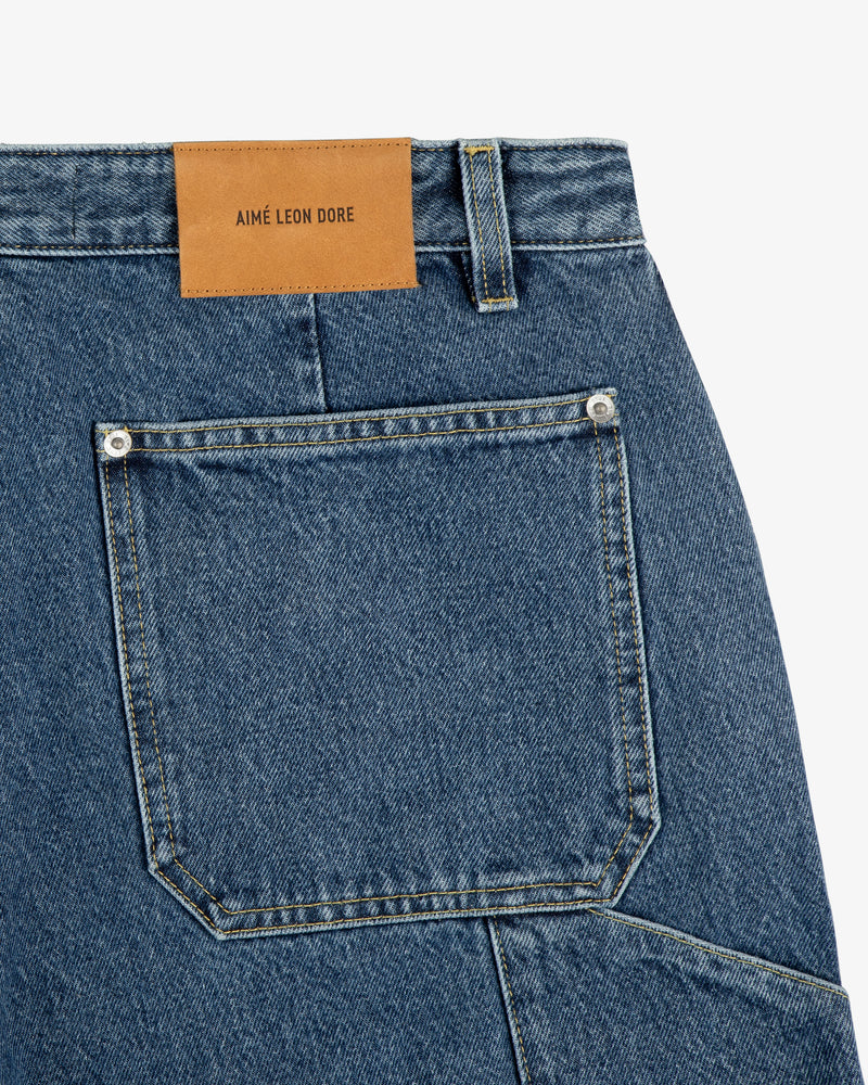 Close-up of blue Denim Carpenter Pant with a brown leather AIME LEON DORE patch above the back pocket.