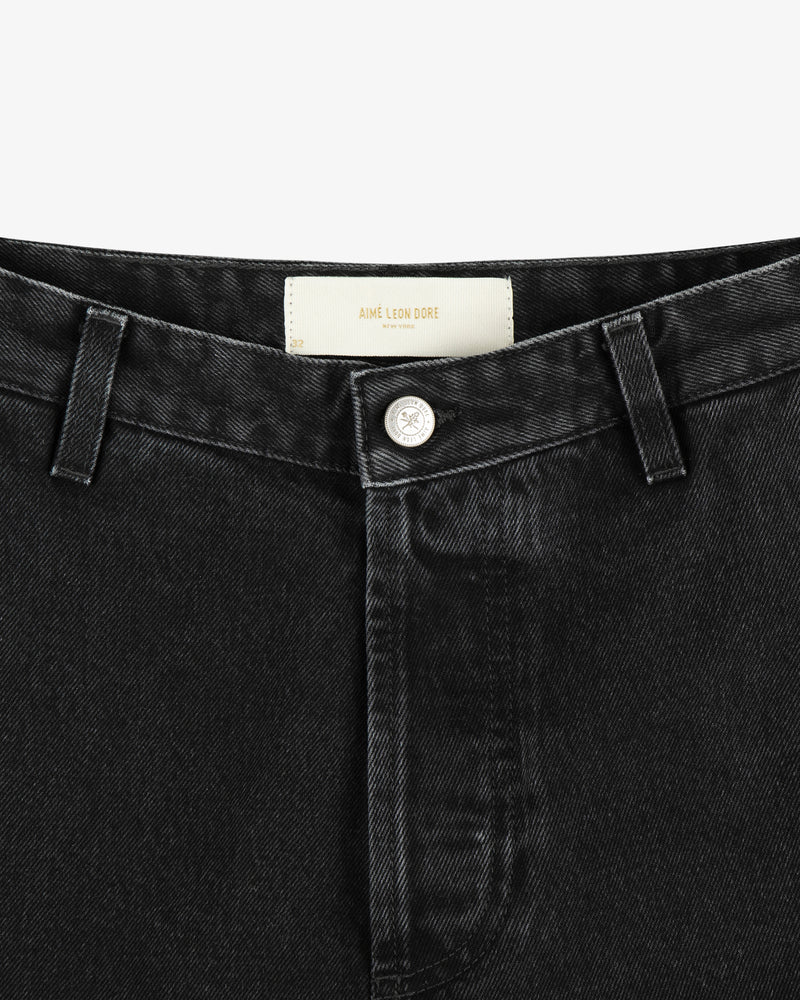Close-up of the waistband and button of black Denim Carpenter Pant featuring an Aimé Leon Dore label inside.