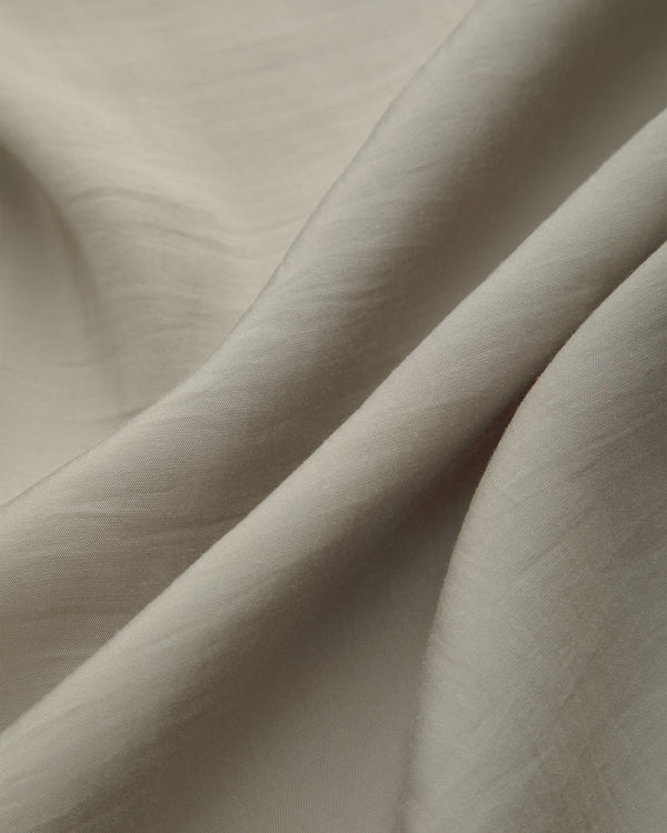 Close-up of Lightweight Leisure Shirt in light beige, showing gentle folds and a smooth, subtly textured surface.