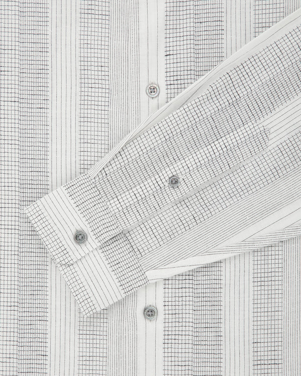 Close-up of the Fil Coupé Leisure Shirt in white with thin grid lines, buttons, and a folded sleeve.