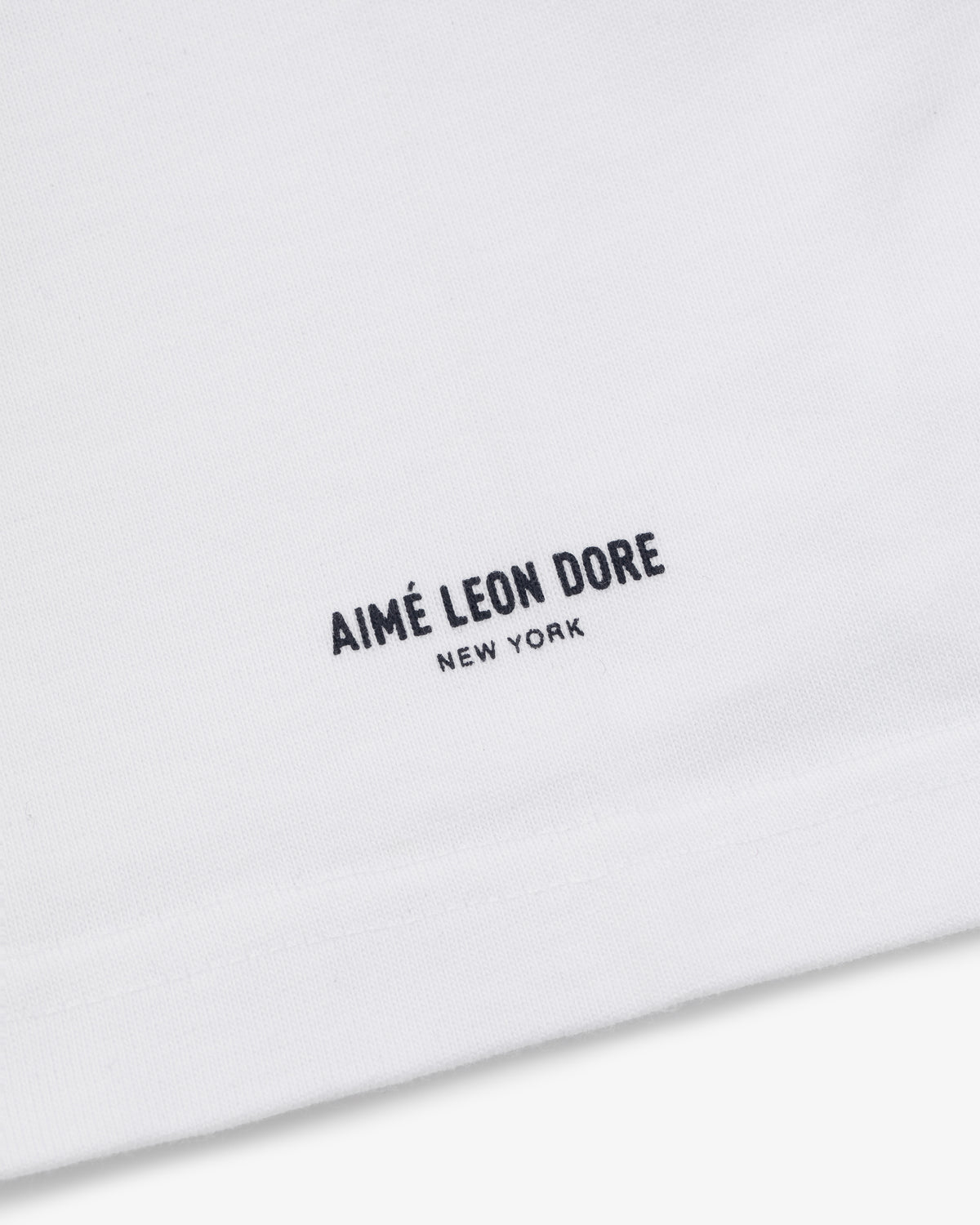 White Yankees Chainstitch Pocket Tee with minimalist AIMÉ LEON DORE NEW YORK text in black near the hem.