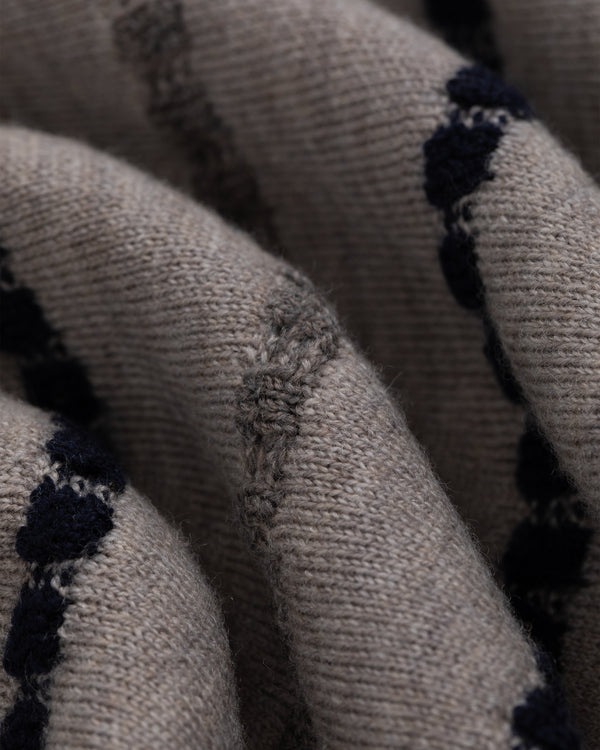 Close-up of Jacquard Stripe Polo Cardigan: beige knit with black dotted stripes and visible woven textures.