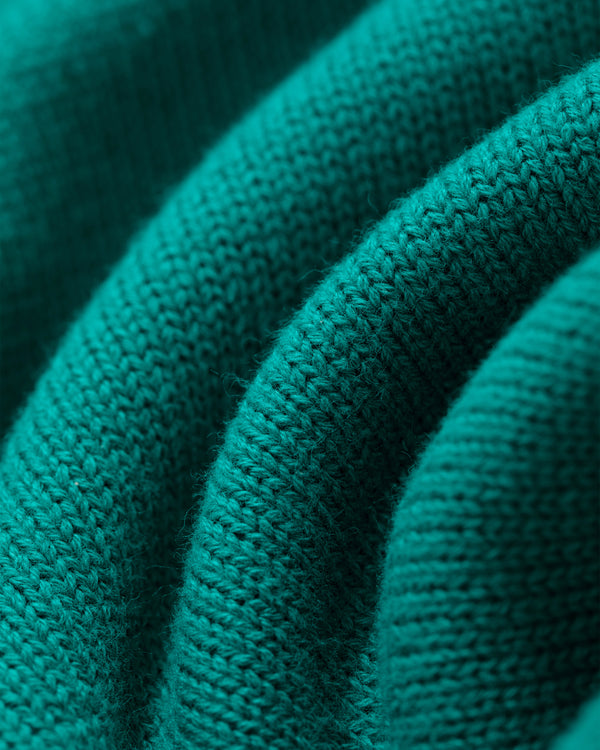 Close-up of Heritage Mockneck Sweater in green, showing textured knitted ridges and detailed stitching.