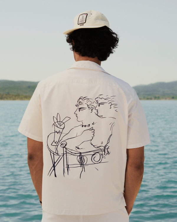 A person in a Fassianos "Rendez - Vous" Camp Shirt stands by a lake, facing away from the camera.